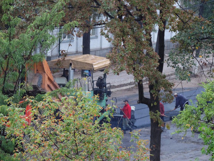 Дорожники во время дождя на улице Раззакова в Бишкеке укладывают асфальт (фото)